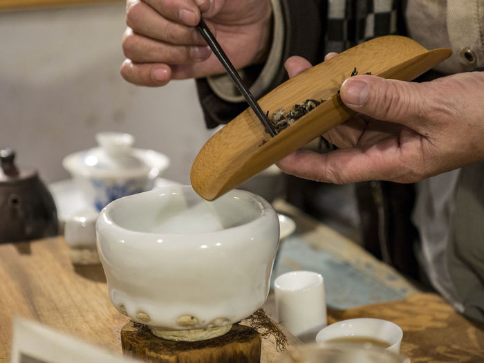 Midsection of man preparing oolong tea
