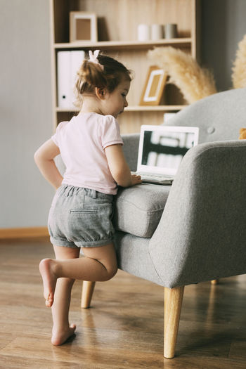 A charming girl is playing or watching cartoons on her laptop. childhood, recreation, cartoon time