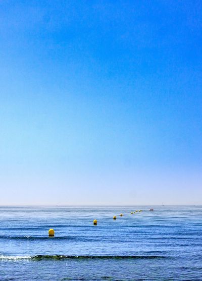 Scenic view of sea against clear blue sky