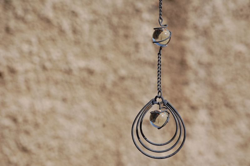 Close-up of pendant hanging against textured wall