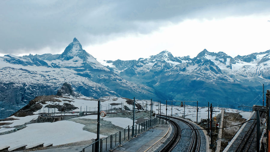 High angle view of bridge leading towards snow covered mountains