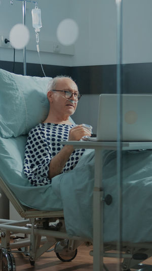 Man looking at camera while sitting on bed