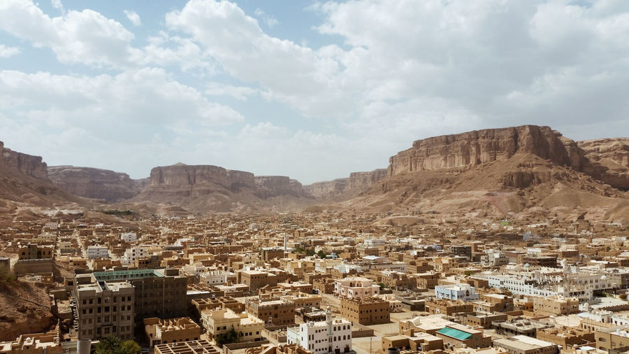 Aerial view of a valley old arab town in yemen against mountain and sky