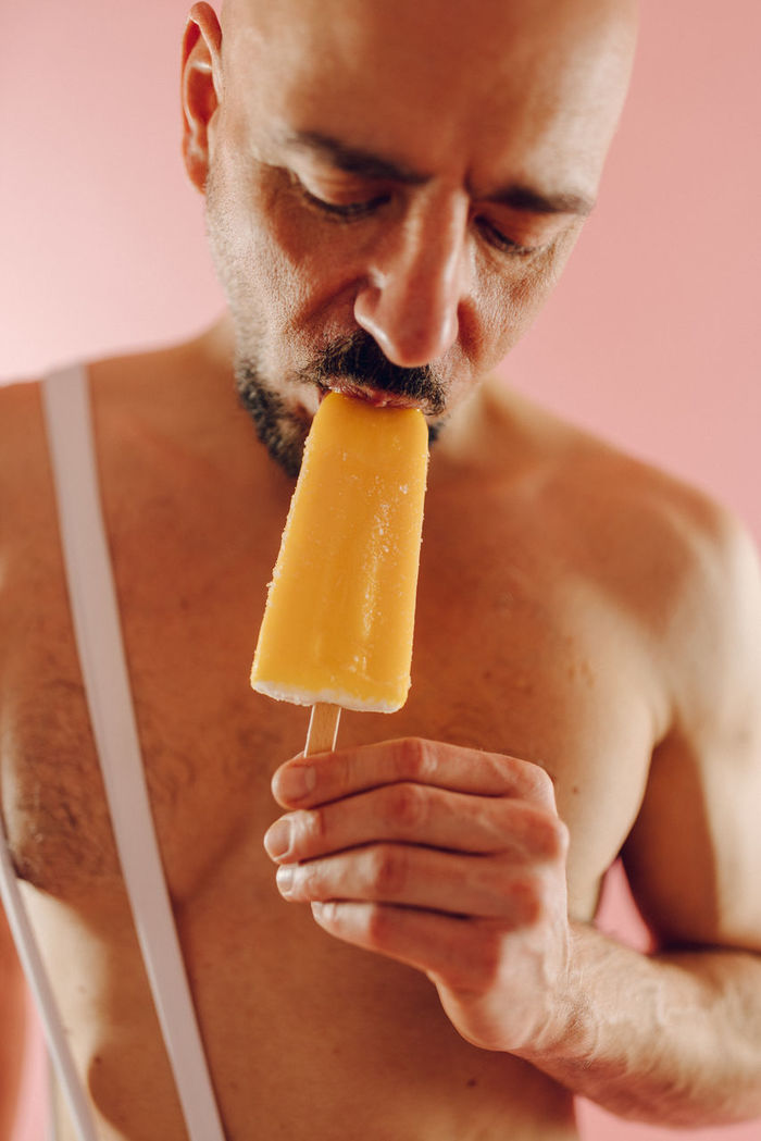 CLOSE-UP OF A MAN EATING ICE CREAM IN CUP