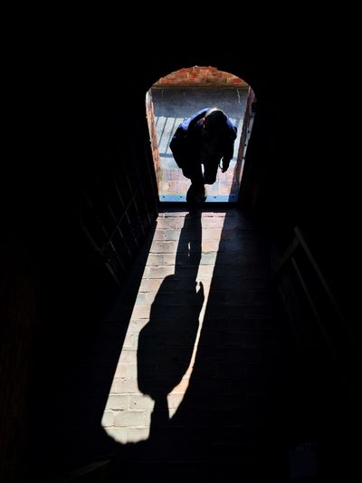 Rear view of a woman walking on tiled floor