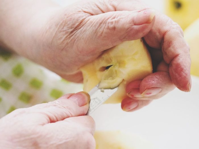 Cropped image of hands cutting fruits