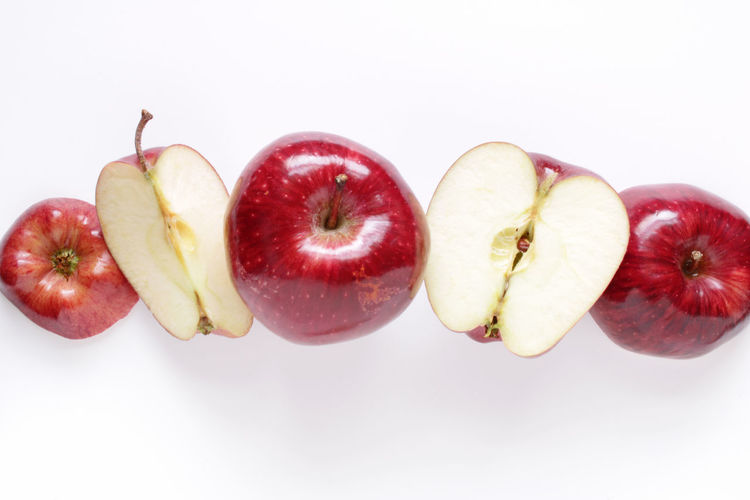 High angle view of fruits and apple against white background