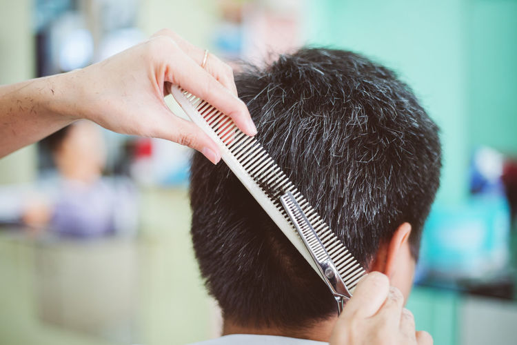 Rear view of man getting haircut
