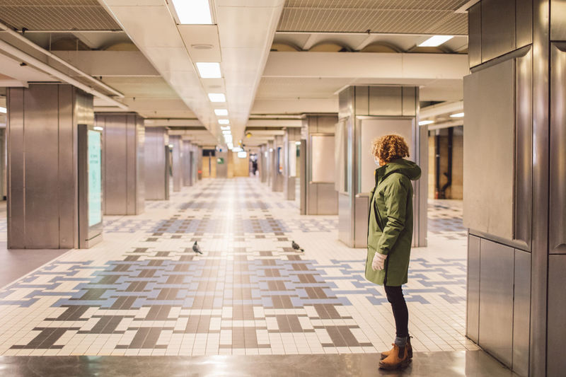 Rear view of woman walking in corridor of train station