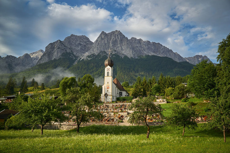 Church amidst trees against mountain range