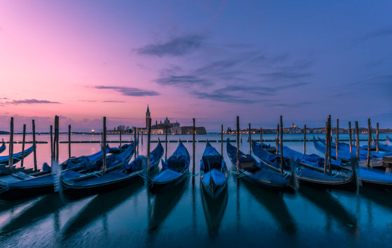 Gondolas on grand canal against sky during sunset in city