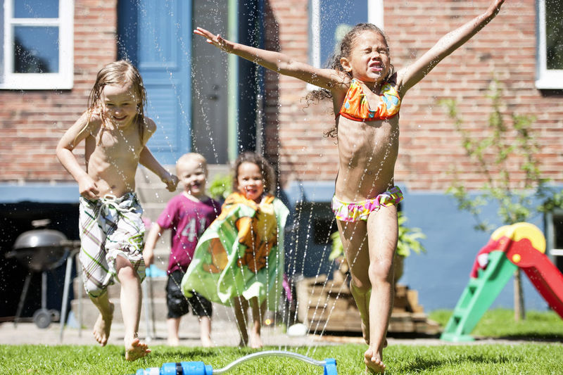 Children playing with water in garden
