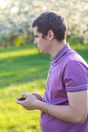 Side view of young man using mobile phone