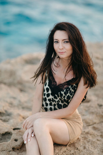 Portrait of a beautiful young woman sitting on beach
