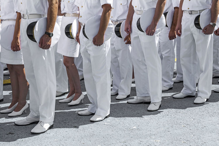 Low section of naval officers standing on ground during event