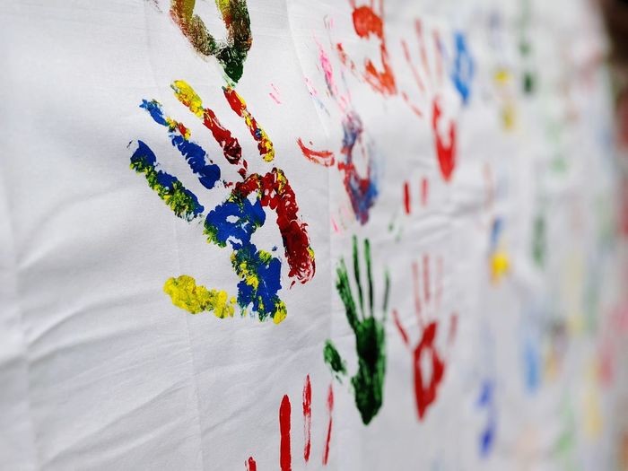 Close-up of colorful handprints on fabric
