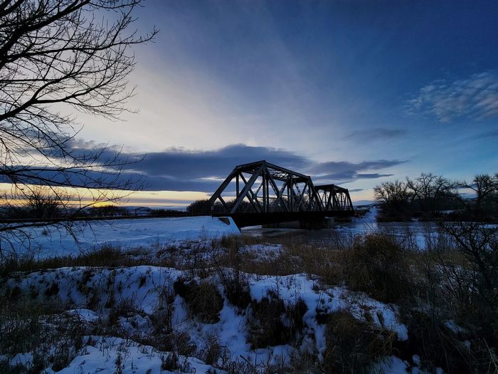 Bridge over river against sky during sunset