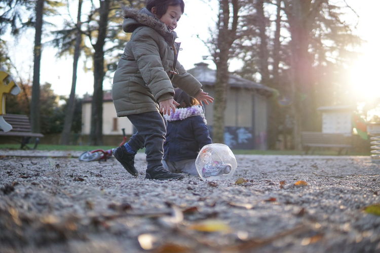Boy playing with ball outdoors during winter