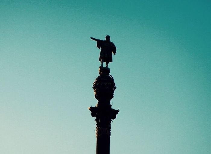 Low angle view of silhouette statue against clear sky