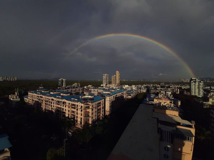View of rainbow over buildings in city