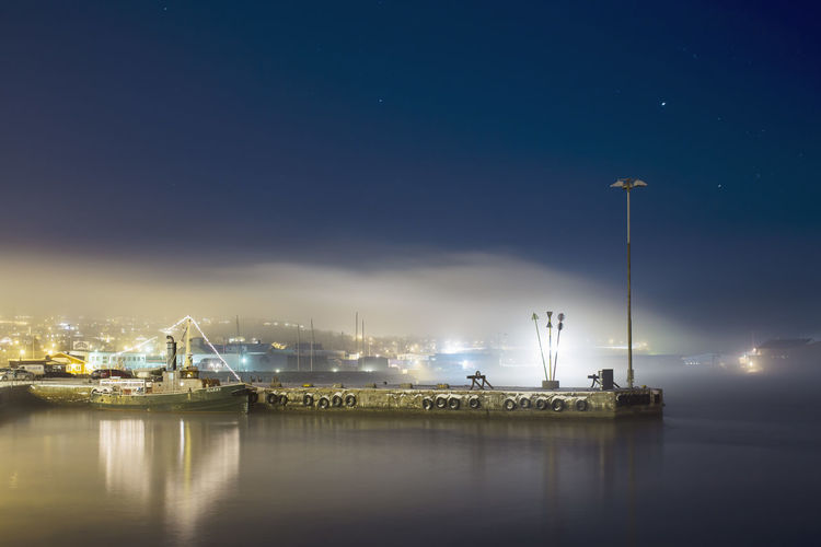 Illuminated commercial dock on lake at night