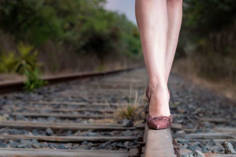 Low section of person standing on railroad track