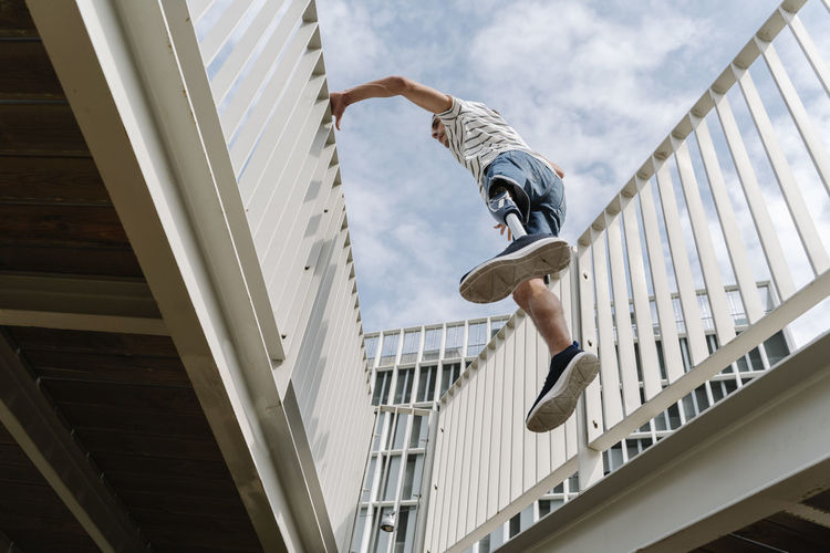 Low angle view of man jumping on wall