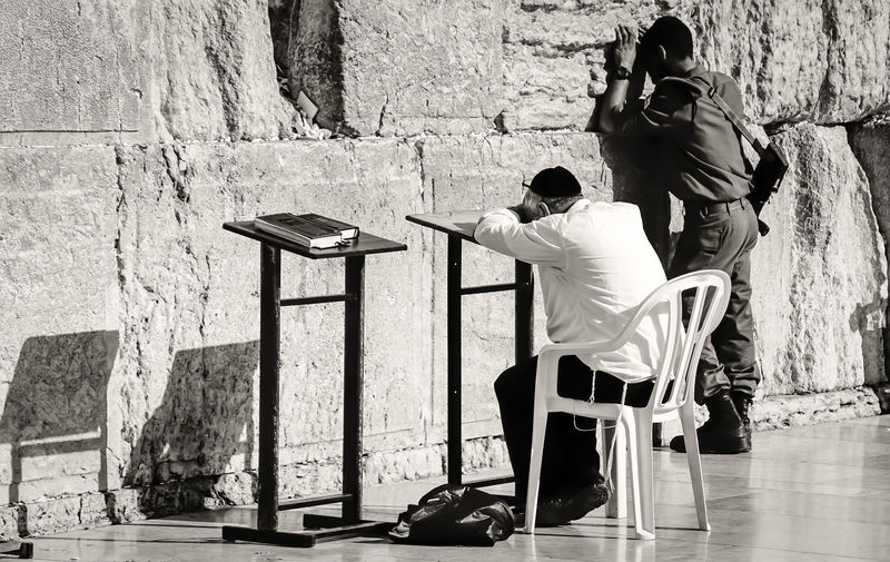 Full length of people praying by wailing wall