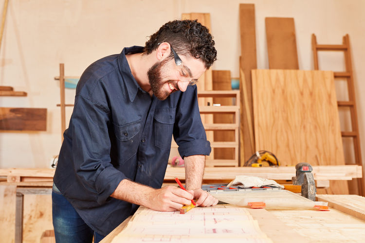 Smiling carpenter working at workshop