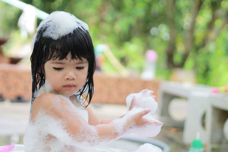 Close-up of a girl taking bath outdoors