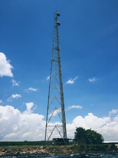Low angle view of a cell tower against blue sky