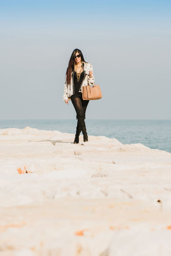 Portrait of fashion young woman standing at beach