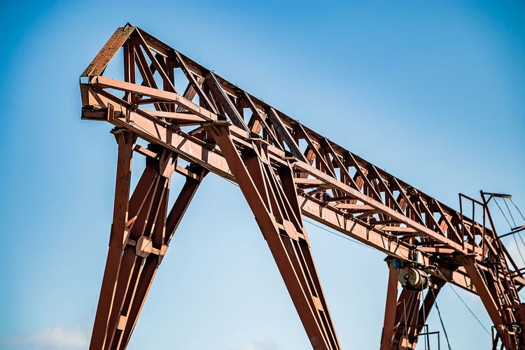 Old rusty gantry crane at abandoned construction site. construction machinery against blue sky. 