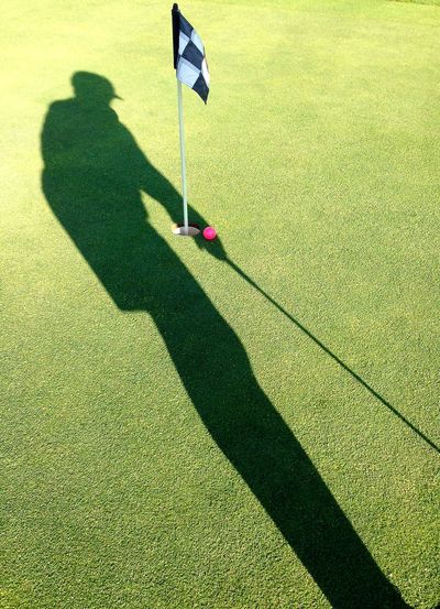 Shadow of person on golf court