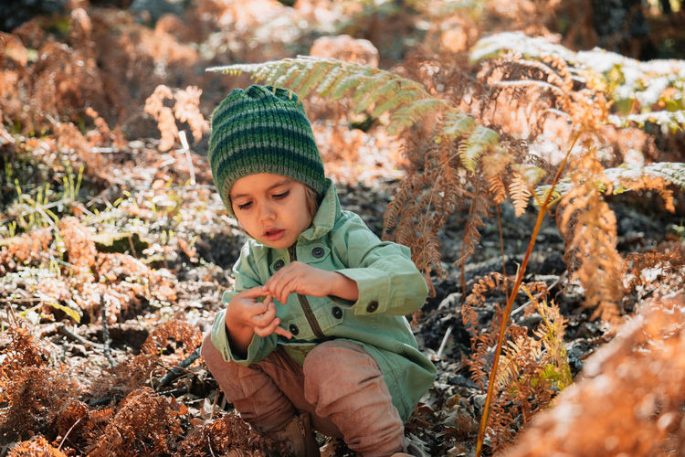 Full length of a boy holding autumn leaf