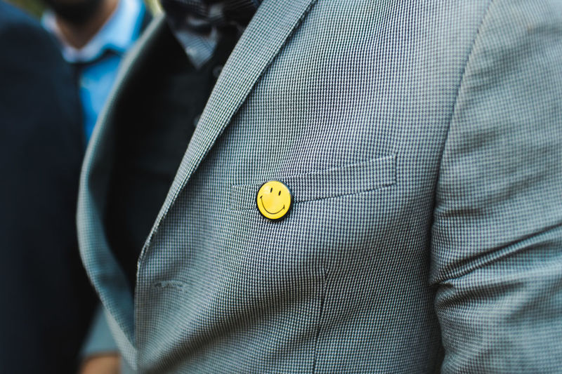 Midsection of man with anthropomorphic smiley face over pocket