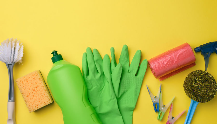 Rubber green gloves for cleaning, red trash can plastic bag roll and plastic bottle with 