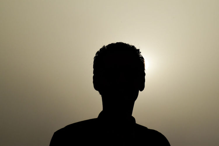 Close-up portrait of silhouette man standing against sky during sunset