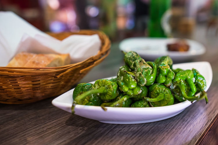 Close-up of green chili peppers in plate on table