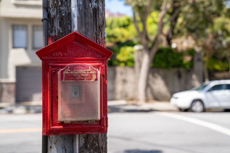 Close-up of red mailbox on road in city