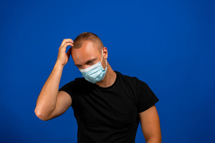 Man standing against blue background