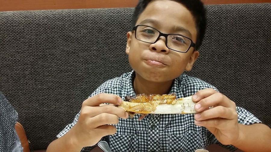 Close-up of boy eating food in restaurant