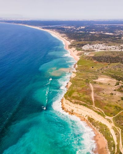 Aerial view of wild coastline with atlantic ocean waves rolling on the cliffs near praia da foz