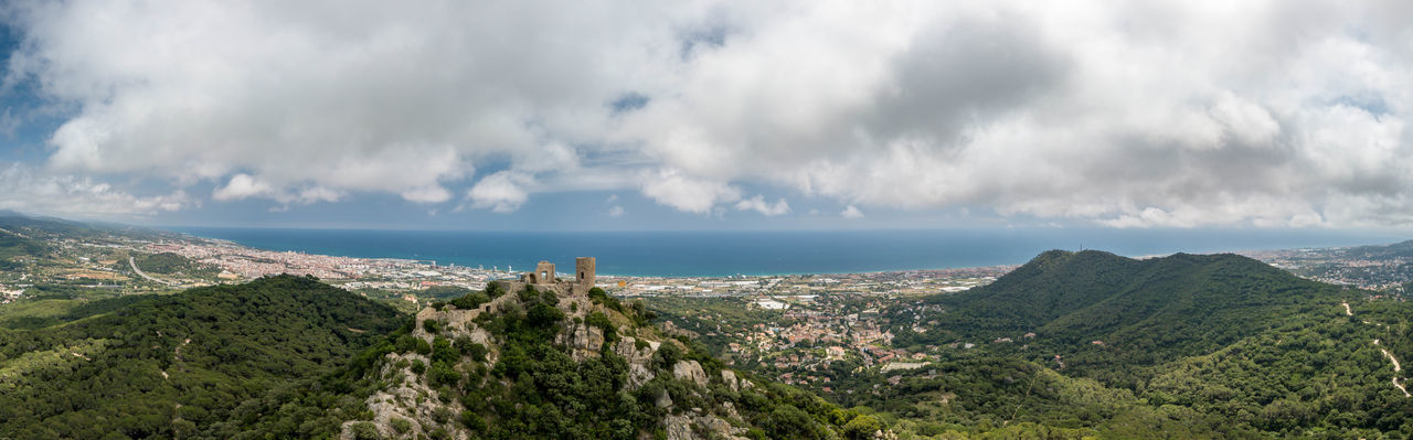 Panoramic view of castell de burriac and sea against sky