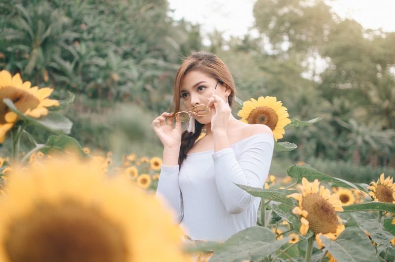 Portrait of beautiful young woman holding flowering plant