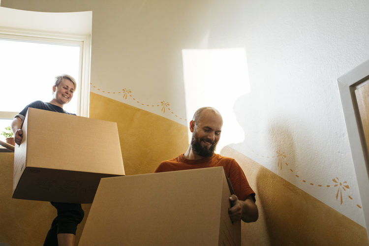 People carrying cardboard boxes at staircase