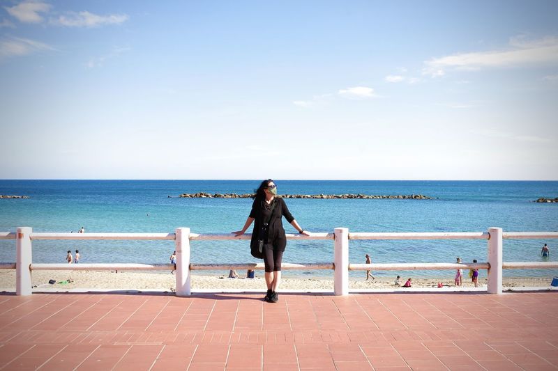 Woman looking at sea against sky