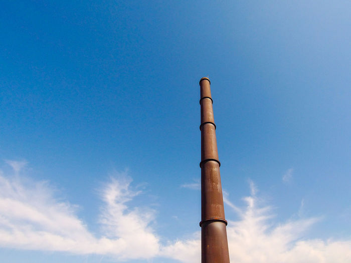 Low angle view of smoke stack against sky