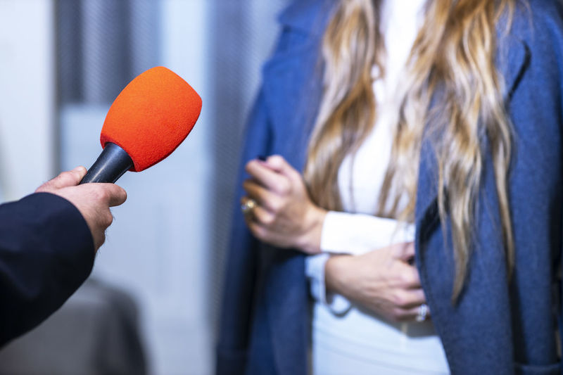 Tv reporter making media interview with unrecognizable female person