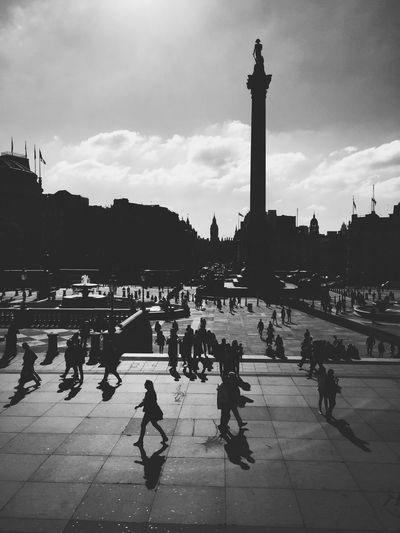Silhouette people and nelson column at trafalgar square against sky